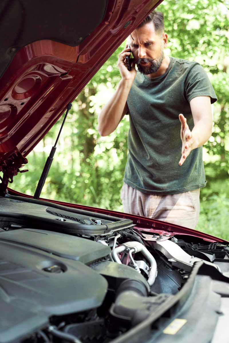 Junger Mann prüft Getriebeschaden bei Schrottauto Ankauf Neuss